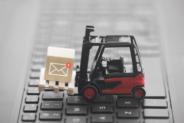 Fototapete - Forklift with new email graphic on wooden block over laptop keyboard 