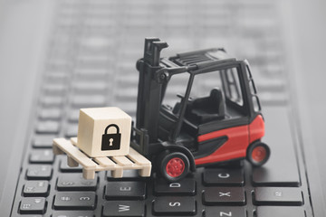 Poster - Forklift with lock graphic on wooden block over laptop keyboard