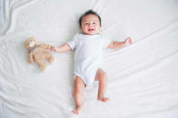 portrait of a crawling baby on the bed in her room, adorable baby boy in white sunny bedroom, newbor