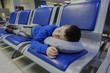 © Michael - Tired little boy sleeping on chair while waiting flight at the airport.