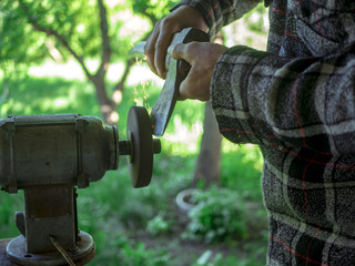 close up hand grinding axe outdoor with many sparkles