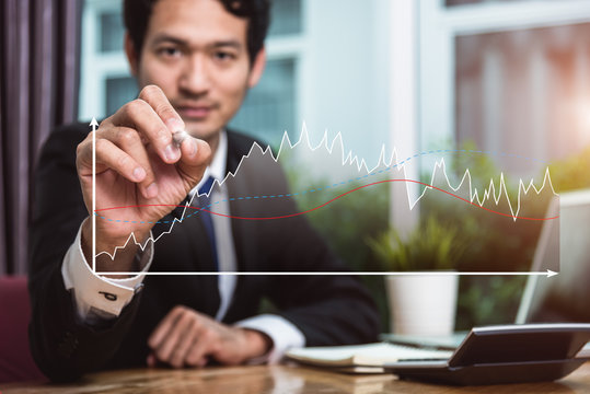 Business man writing growth chart graph