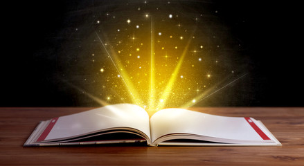 Wall Mural - Yellow lights and sparkles coming from an open book 