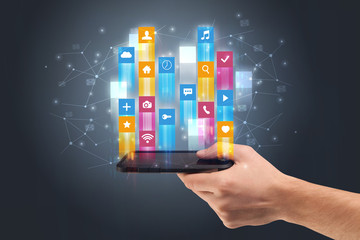 Businessman hand using phone with flying application icons around
