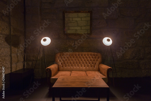 Leather Sofa Lamps And Table In Dark Interior Stone Wall On Leather Sofa Lamps And Table In Dark Interior Stone Wall On Background Brutal Atmosphere