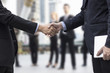 © khwanchai - Successful negotiating business concept, Businessmen shaking hands after finishing meeting or setting  goals and planning way to success in front of team work