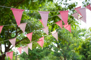 Wall Mural - pink triangle flags hang on white rope in garden for decorative party