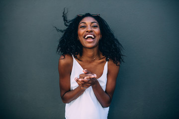 Portrait of a woman standing against a wall