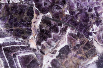 Elegant violet amethyst texture with cracks on surface.