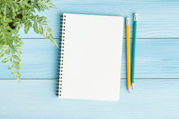 Wall Mural - blank notebook with and pencil on blue background,flat lay photo of notebook for your message