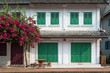 Flowering tree and old French colonial era building at the old town in Luang Prabang, Laos, on a sunny day.