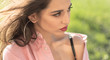 Woman on calm face with make up, nature on background, defocused. Girl with big rings earrings wears unbuttoned shirt and black lingerie. Lady with nude shoulder looks attractive. Femininity concept.