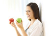 © Antonioguillem - Smiley girl holding two red and green apples