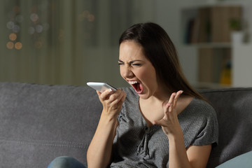 Wall Mural - Angry woman shouting at the smart phone