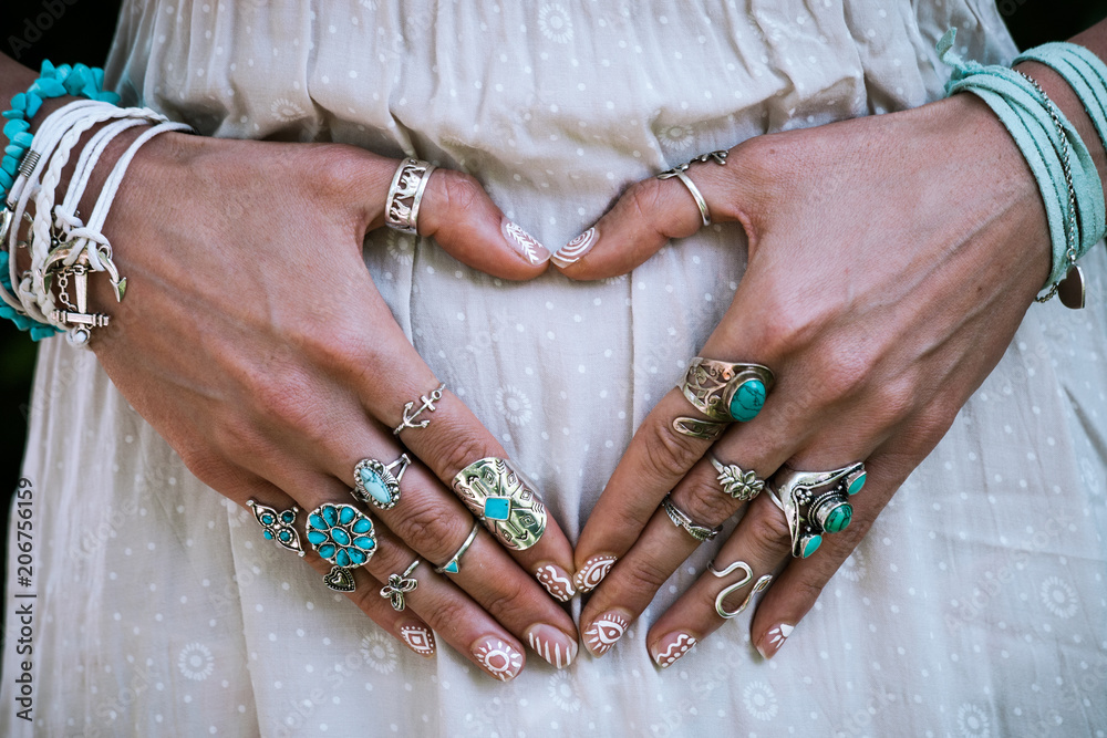 Obraz na płótnie closeup of young woman hands in heart shape with lot of boho style jewrly, rings and bracelets outdoor w salonie