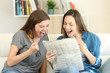 Excited friends reading newspaper news