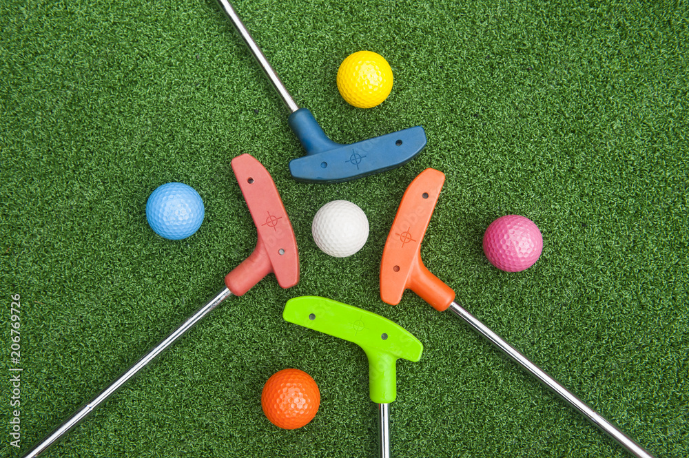 Four Mini Golf Putters with Balls - obrazy, fototapety, plakaty 
