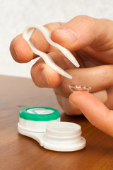 Sticker - hands putting on contact lenses, closeup