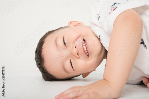 Happy Boy Toddler Lay Down On The Floor With Smile Face On White