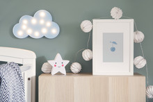 Stylish Nursery Interior With Mock Up Photo Frame , Cotton Lamps, Star And Blue Cloud. Green Background Wall.