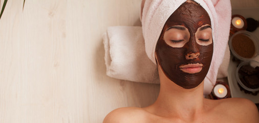 Chocolate Luxury Spa. Facial Mask. Spa therapy for young woman with cosmetic mask at beauty salon. Day spa treatment