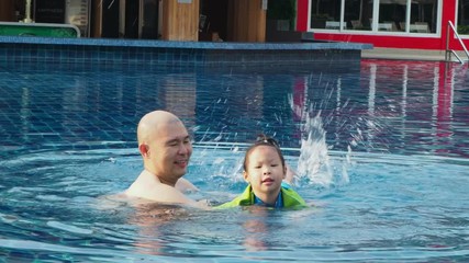 Wall Mural - Little asian girl swimming with her father at swimming pool