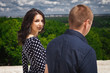 © luckyphoto - young teenagers walking in nature. girl with long brunette hair wearing black dress in white peas looking back, boy in blue shirt in pattern