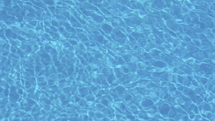 ripple water in swimming pool with sun reflection