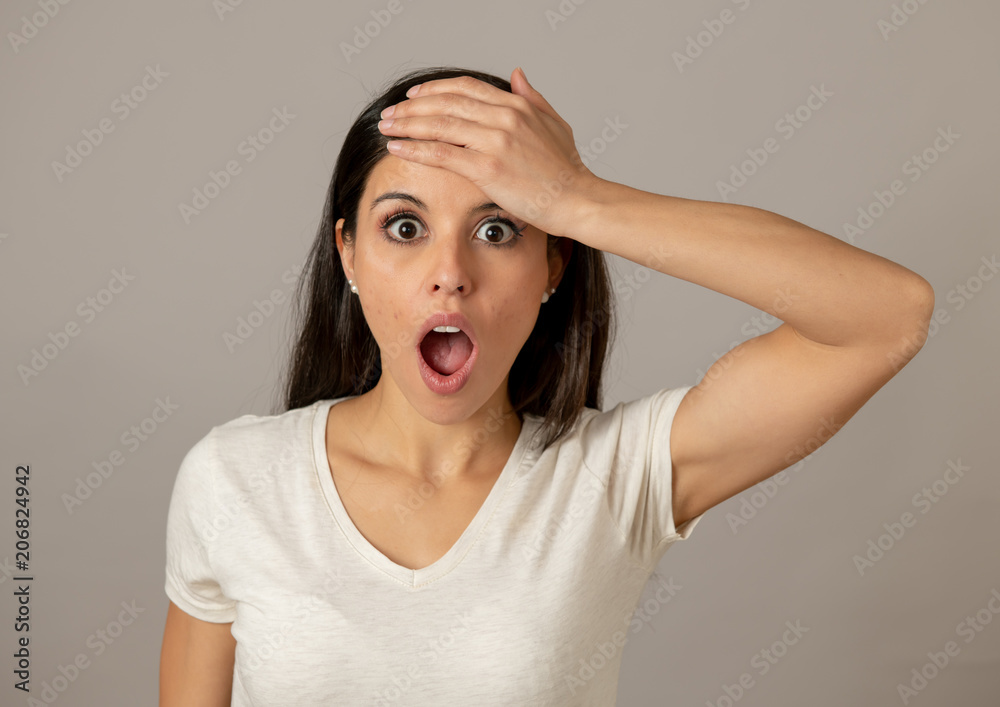 Young attractive woman with a surprised and shocked face, eyes and mouth wide open. Stock Photo | Adobe Stock