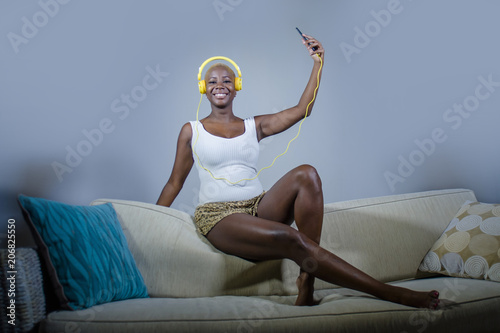 Fotografia young happy and beautiful relaxed black afro American woman listening to music w