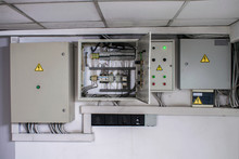 Several Electrical Boxes On The Control Panel Of Power Supply. An Open And Three Enclosed Electrical Cabinet. Alarm System And Switching Of Backup Power Supply