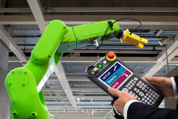 Poster - Engineer with teach pendant device. Programming robot with robotic arm. Smart factory 