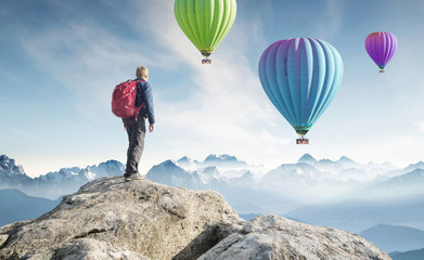 Wall Mural - tourist on the peak of high rocks. sport and active life concept.