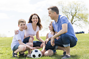 Wall Mural - Family of four outdoors in a field having fun