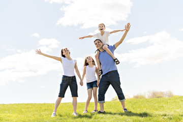 Wall Mural - Family of four outdoors in a field having fun