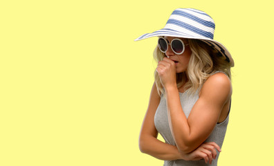 Young woman wearing sunglasses and summer hat sick and coughing, suffering asthma or bronchitis, medicine concept