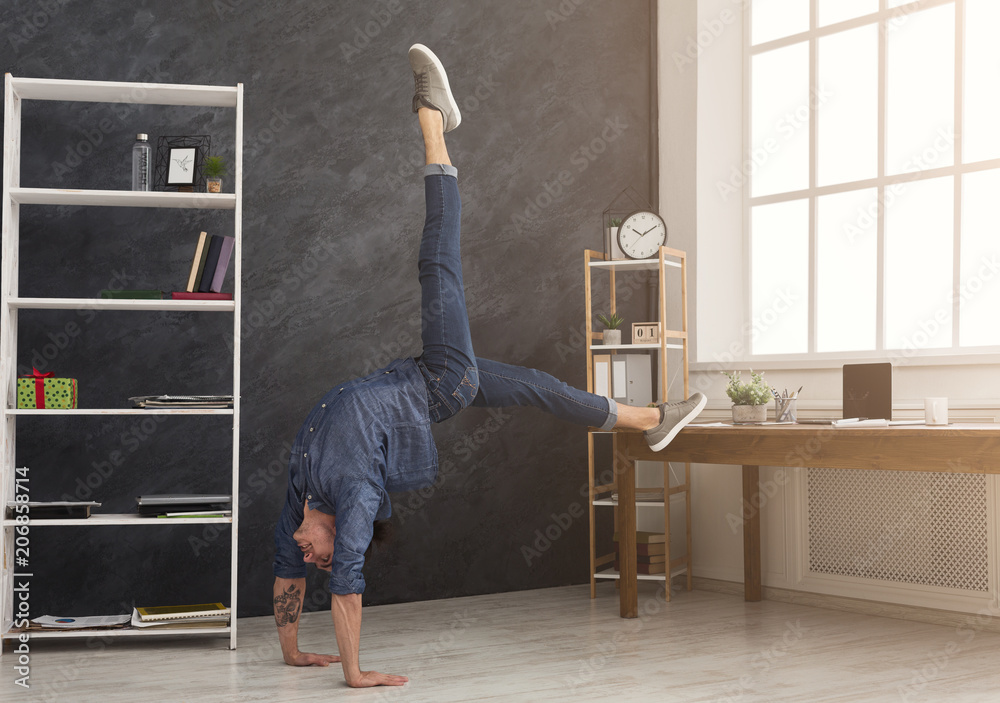 Flexible man practicing yoga at workplace