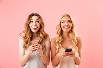 Poster - Two cheerful pretty women in pajamas holding smartphones