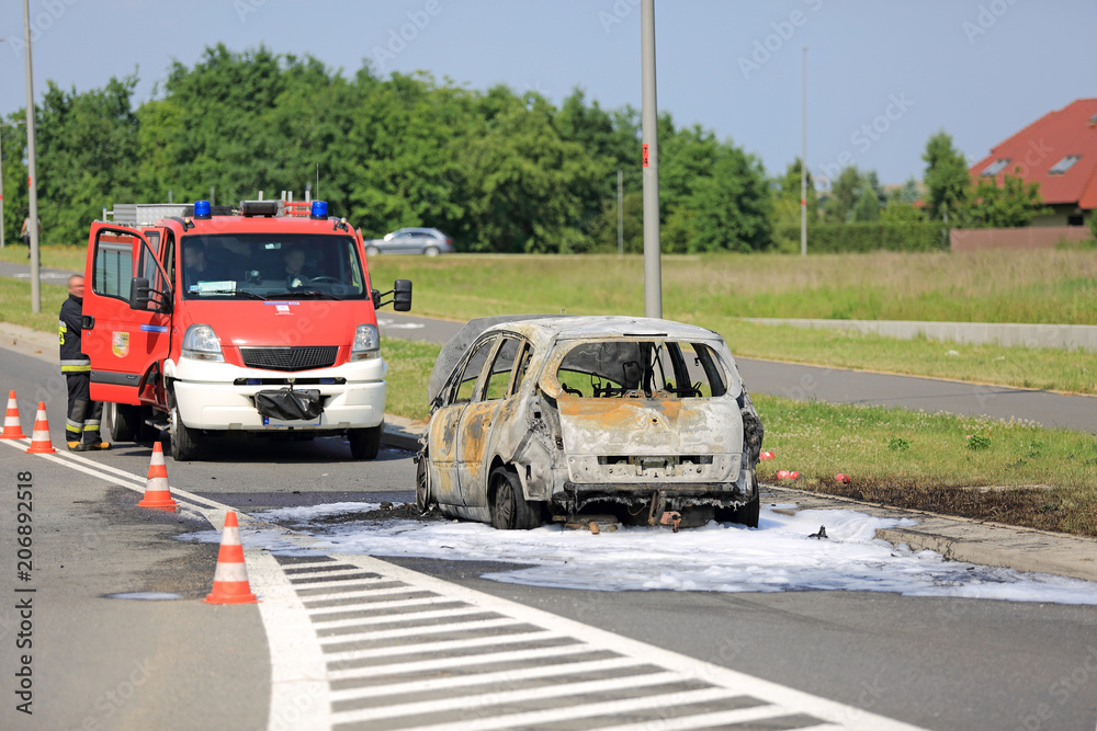 Spalony samochód osobowy na ulicy, pożar ugaszony przez straż pożarną. - obrazy, fototapety, plakaty 
