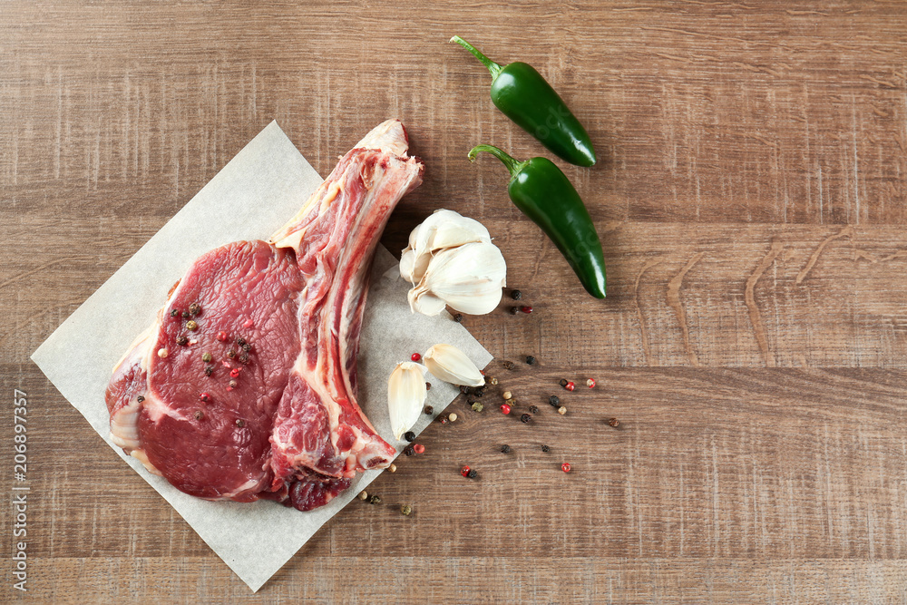 Fresh raw pork rib with spices on wooden table