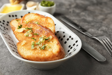 Poster - Plate with delicious homemade garlic bread on table