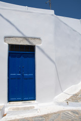 Wall Mural - Traditional wooden blue door and a white stone wall in Amorgos