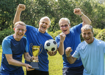 Wall Mural - Team of mature football players winning the cup