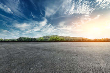 asphalt square road and hills with sky clouds landscape at sunset