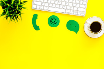 Poster - Customer service concept. Concact information. Phone, message, email signs on office work desk with computer on yellow background top view copy space
