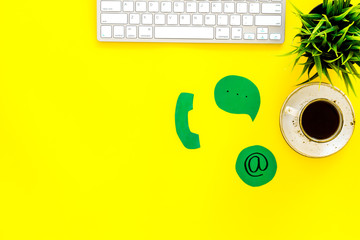 Poster - Customer service concept. Concact information. Phone, message, email signs on office work desk with computer on yellow background top view copy space