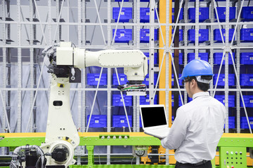 The programmer engineer control the robot for logistic warehouse.The hi-technology logistic industrial.