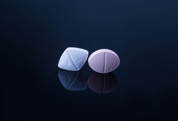 Wall Mural - Medical pills with different size, shape and color on black glass table with reflection.Studio shot.