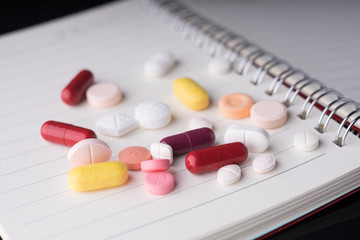 Wall Mural - Medical pills and supplement capsule with a notebook.Medical health concept..