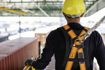 Construction worker wearing safety harness and safety line working on construction